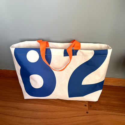 Stor bag med blå tall fra seil, oransje stropper