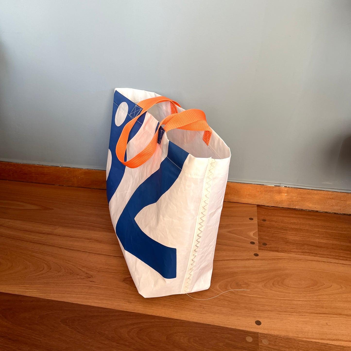 Stor bag med blå tall fra seil, oransje stropper