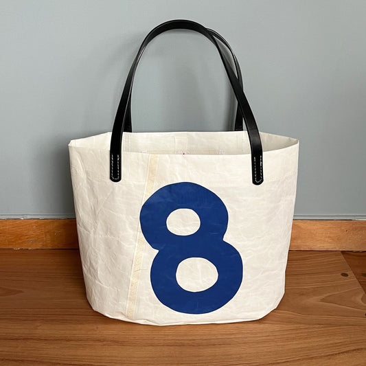 Stor ovalbunnet veske, med 8-tall og sorte "skinn"-remmer