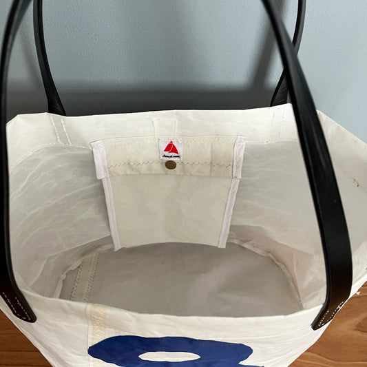 Stor ovalbunnet veske, med 8-tall og sorte "skinn"-remmer