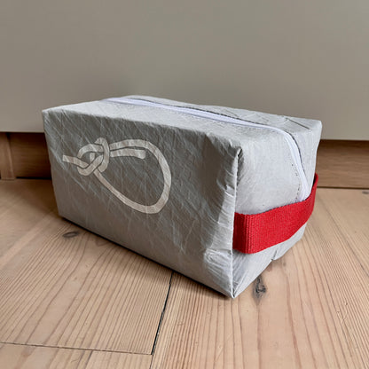 Toalettmappe fra grått Hanse-seil med pålestikk og røde detaler