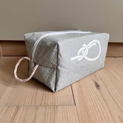 Toalettmappe fra grått Hanse-seil med pålestikk og røde detaler