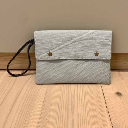 Liten clutch, med stjerneknapper og klaff. Grått seil.